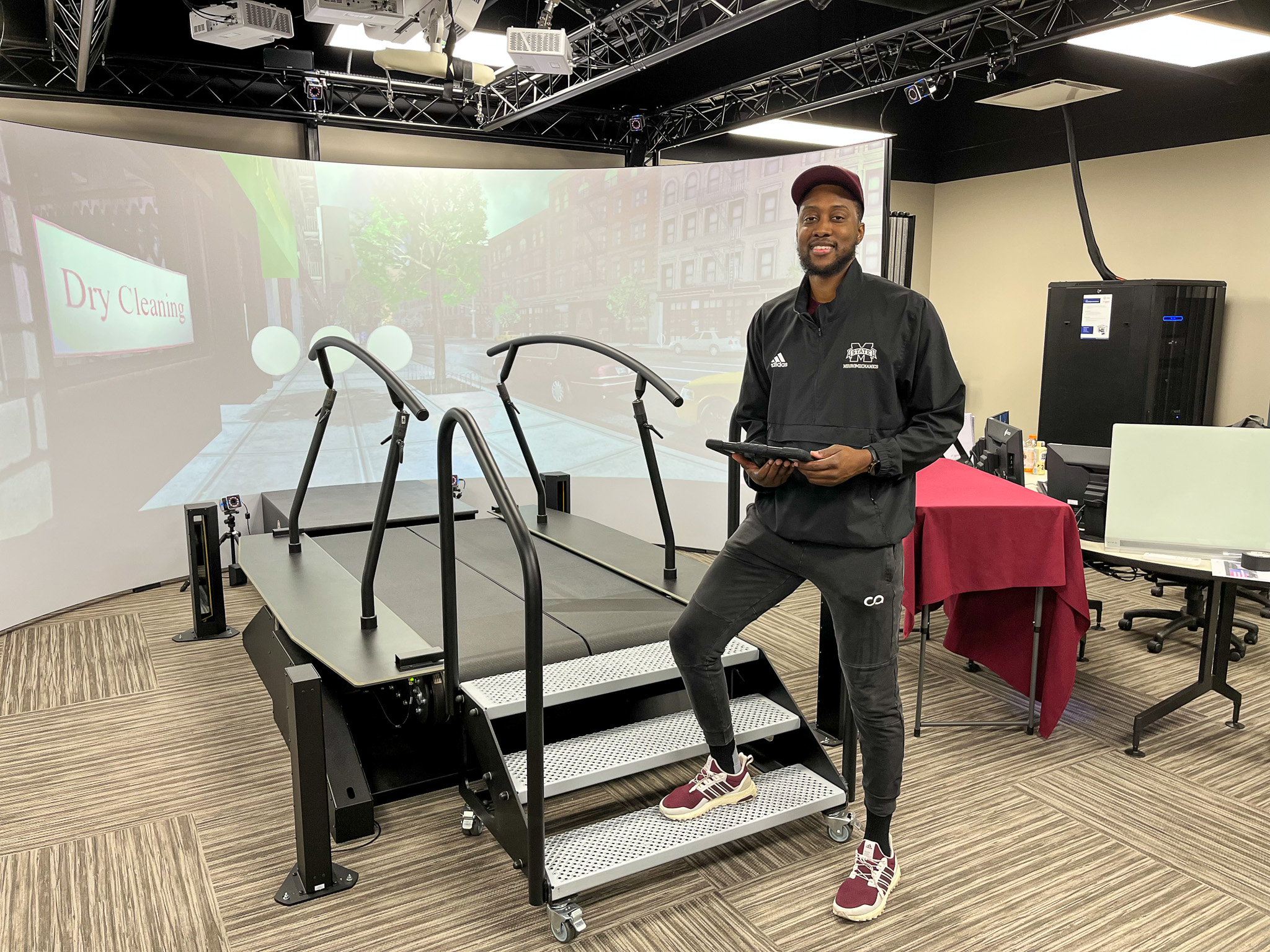 Student standing beside treadmill in research lab